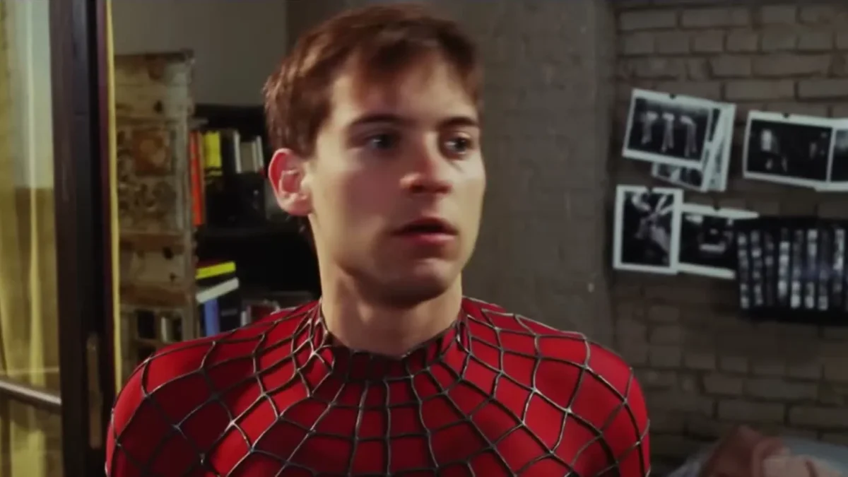 Tobey Maguire as Peter Parker in the Spider-Man suit with the mask off, in his bedroom
