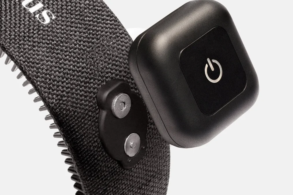 Close-up of the Capillus HairBand's square control pod with its power button, beside the fabric band and its rows of soft teeth