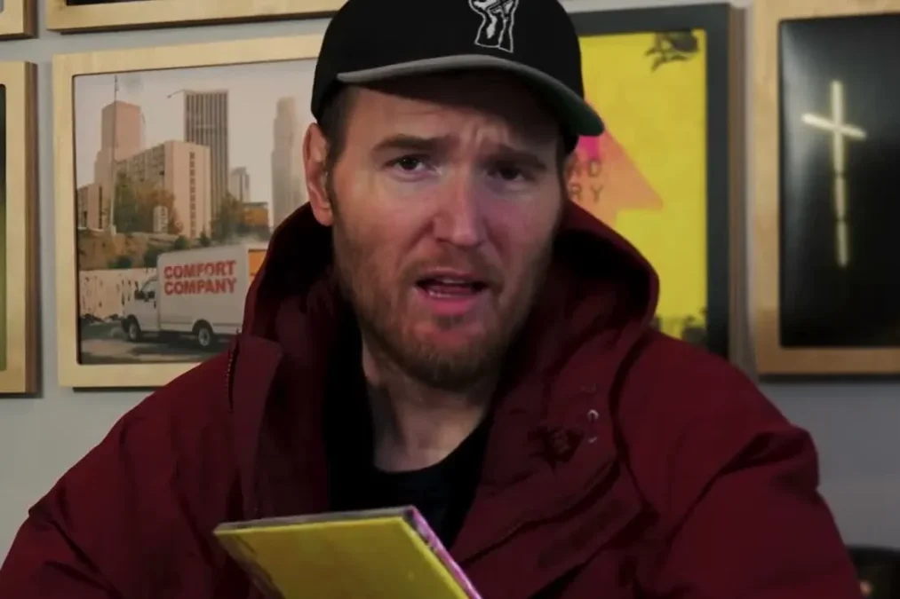 Chad Gilbert looking at the camera in a studio office with framed records on the wall