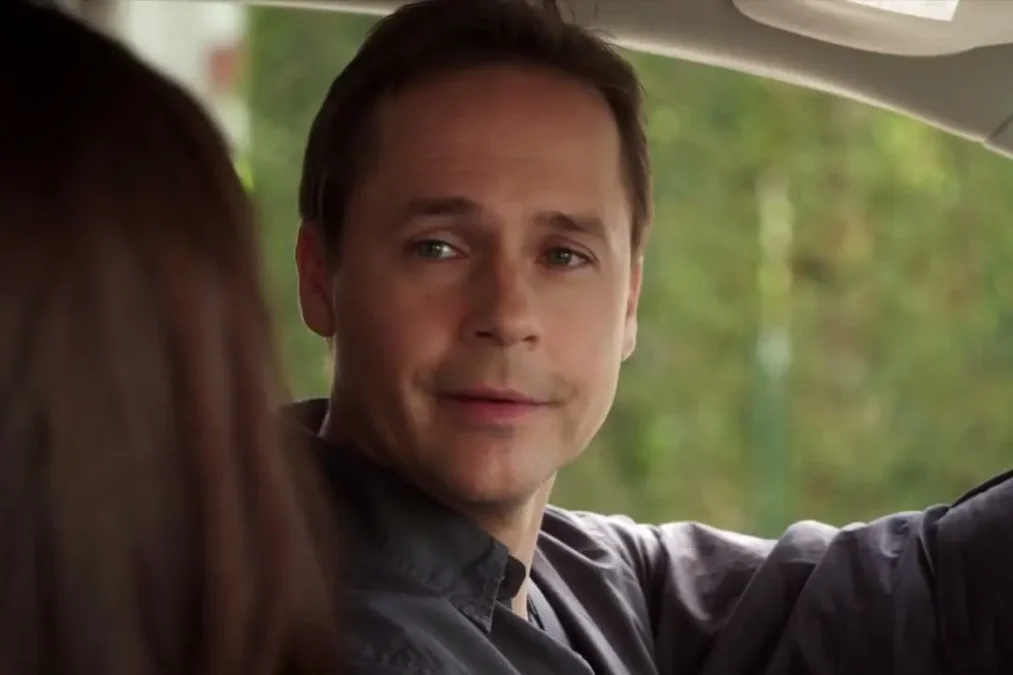 Chad Lowe as Byron Montgomery smiling from the driver's seat of a car in Pretty Little Liars
