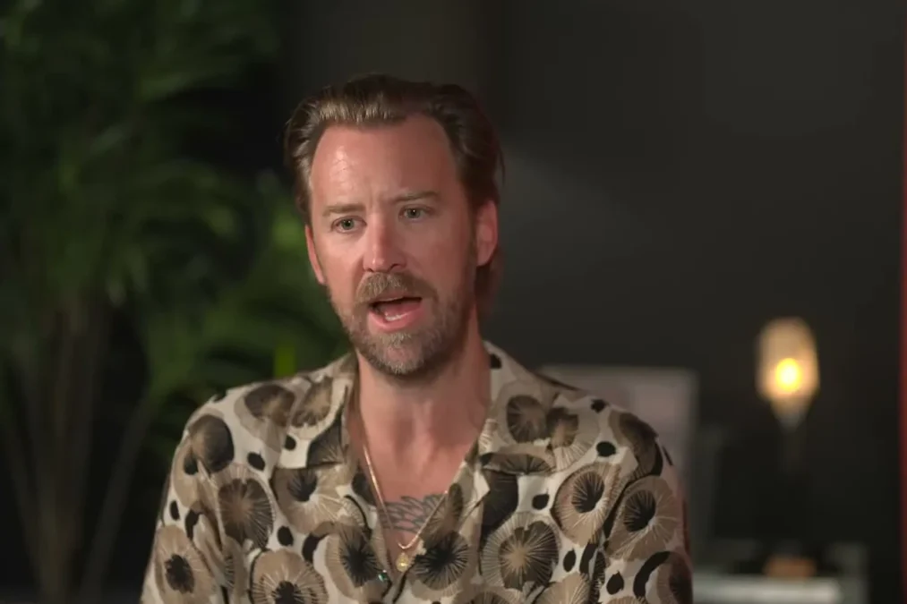 Charles Kelley in a patterned shirt speaking during a sit-down interview
