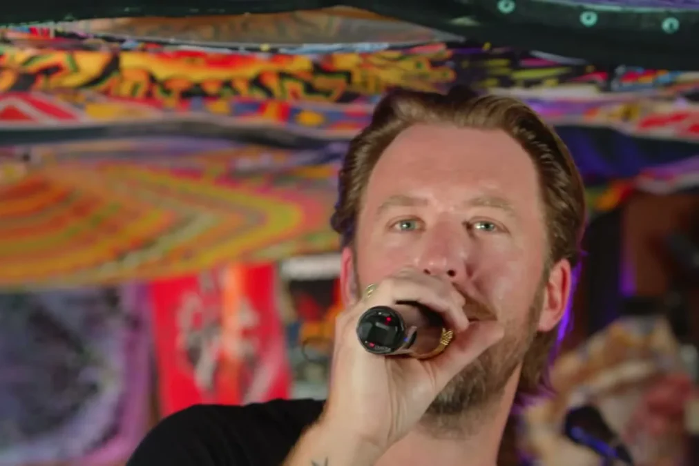 Charles Kelley singing into a microphone inside a van decorated with colorful fabric