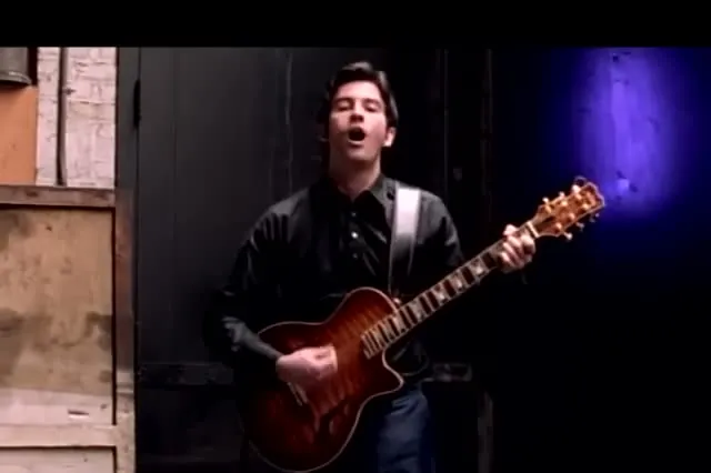 A young Duncan Sheik singing and playing an electric guitar in the Barely Breathing music video