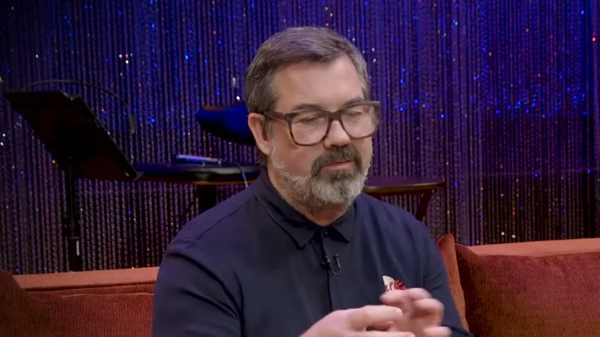 Duncan Sheik, in glasses and a dark shirt, speaking during a TheaterMania interview about Spring Awakening