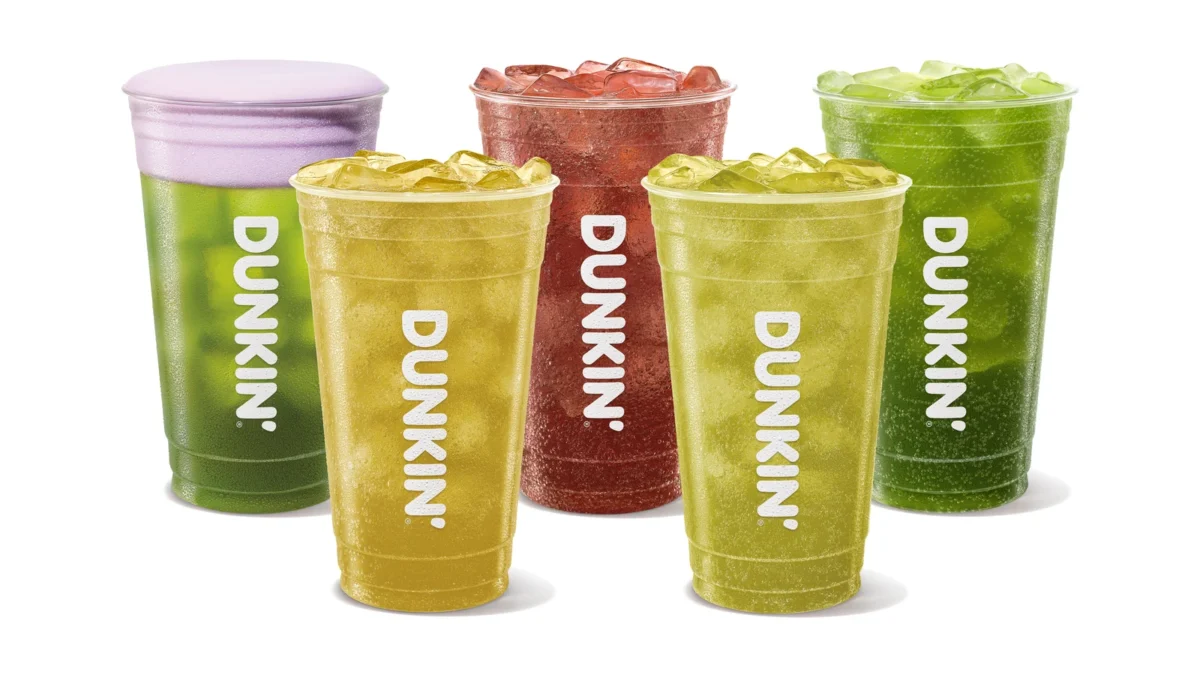 Five Dunkin' iced drinks in green, yellow and red: Sour Apple Energy with purple foam and four Green Apple Dunkin' Zero drinks
