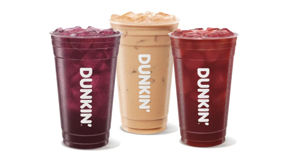 Three Dunkin' iced drinks: a dark purple Midnight Potion Refresher, a Nutty Nightmare Iced Coffee with cream and a red Werewolf Punch Refresher