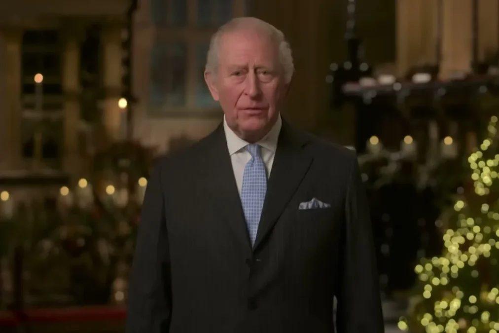 King Charles III standing in a chapel with a Christmas tree during his 2025 Christmas broadcast