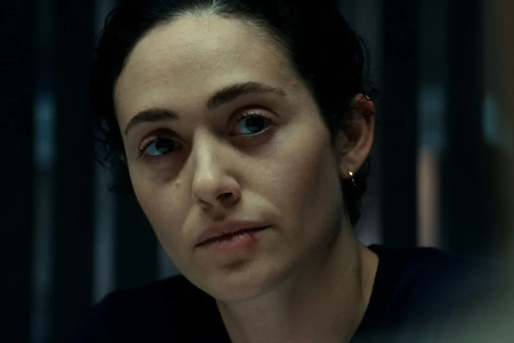 Emmy Rossum as FBI agent Alice Black, with dark curly hair pulled back, in a dim office in Furious