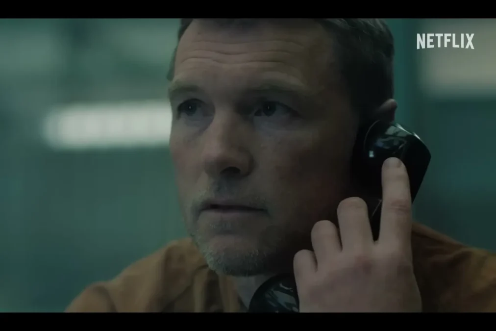 Sam Worthington as David holding a prison visitation phone to his ear in I Will Find You