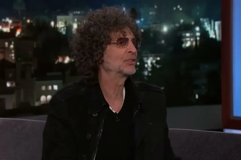 Howard Stern in tinted glasses talking on the Jimmy Kimmel Live couch