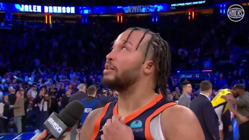 Knicks guard Jalen Brunson in his orange and blue jersey giving a postgame interview at Madison Square Garden