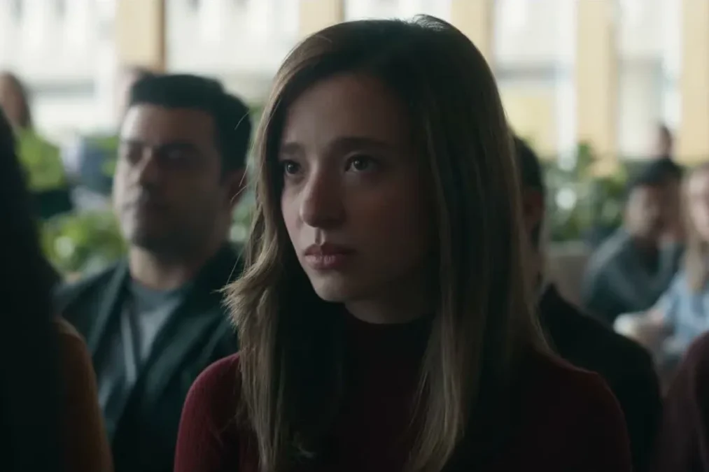 Mikey Madison as Frances Haugen seated in a crowd, looking ahead with a serious expression