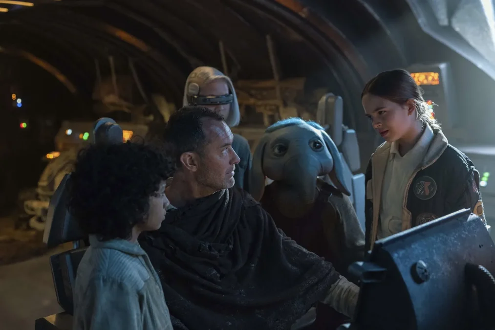 Jude Law as Jod Na Nawood stands with the four kids of Star Wars: Skeleton Crew inside a dim spaceship