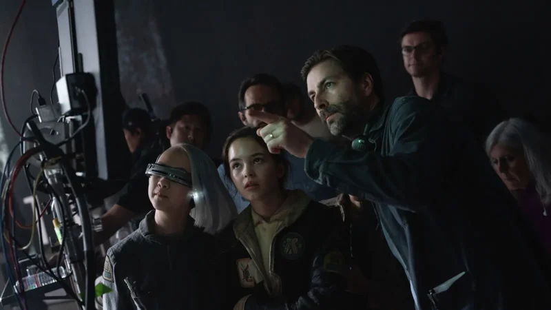 Jon Watts points toward a monitor while directing young actors Kyriana Kratter and Ryan Kiera Armstrong on the set of Star Wars: Skeleton Crew