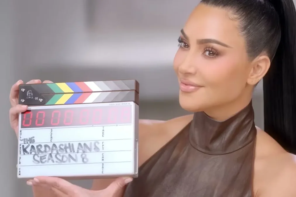 Kim Kardashian holding a clapperboard that reads The Kardashians Season 8