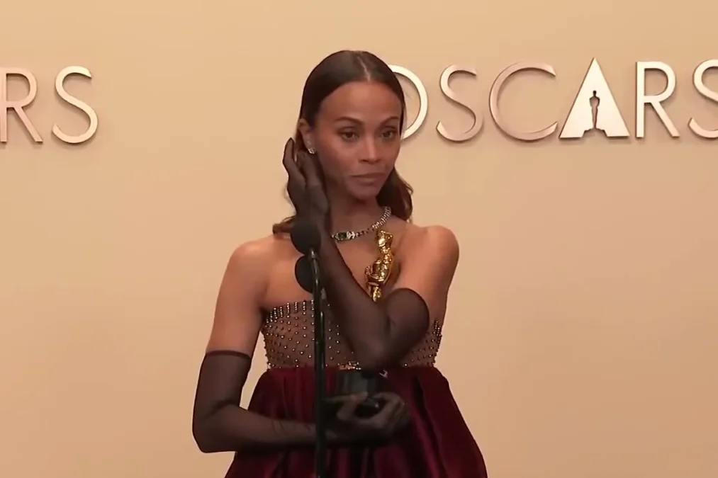 Zoe Saldaña holding her Oscar in the press room at the 97th Academy Awards