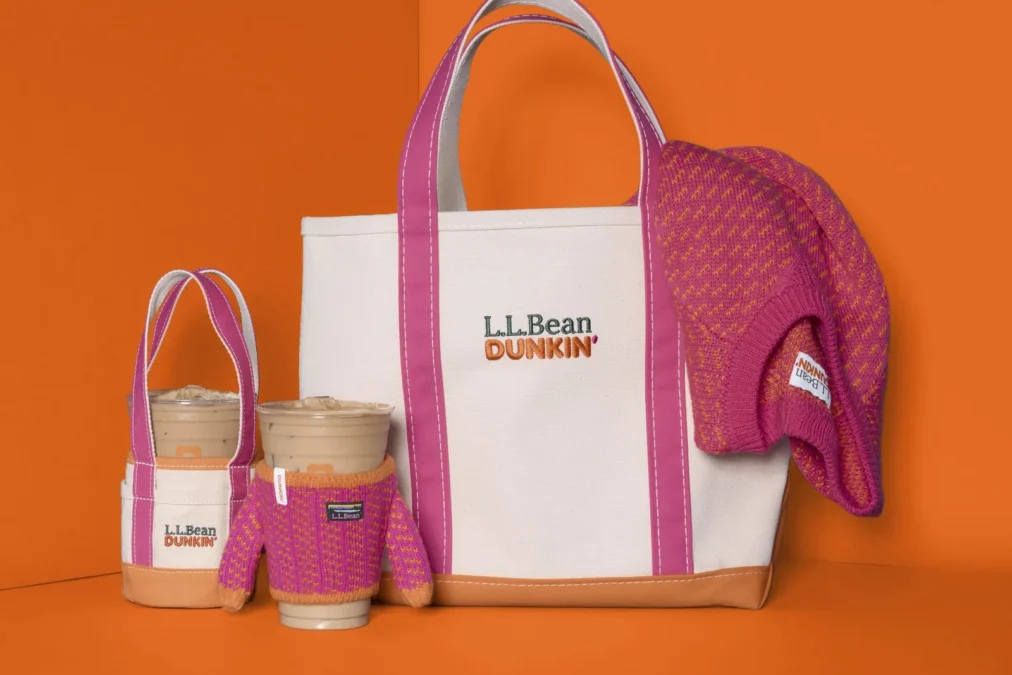 The L.L.Bean x Dunkin' collection on an orange background: a Boat and Tote bag, a small cup-holder tote, a cup in a knit sleeve and a pink Birdseye sweater