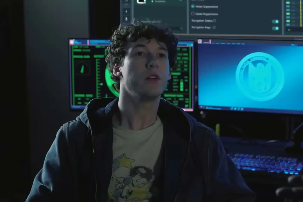 Devin Druid in a hoodie in front of glowing computer monitors