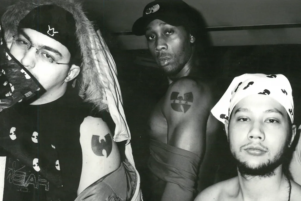 Black-and-white photo of three men showing Wu-Tang Clan tattoos and clothing