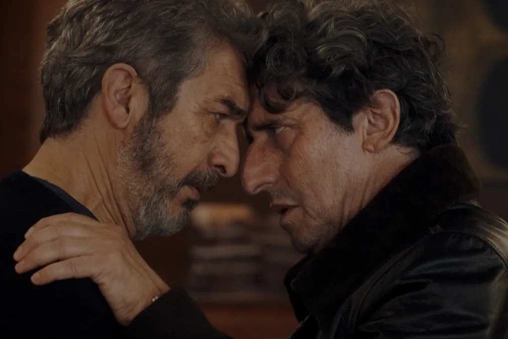 Two men press their foreheads together in a dim room in Therapy Done Right