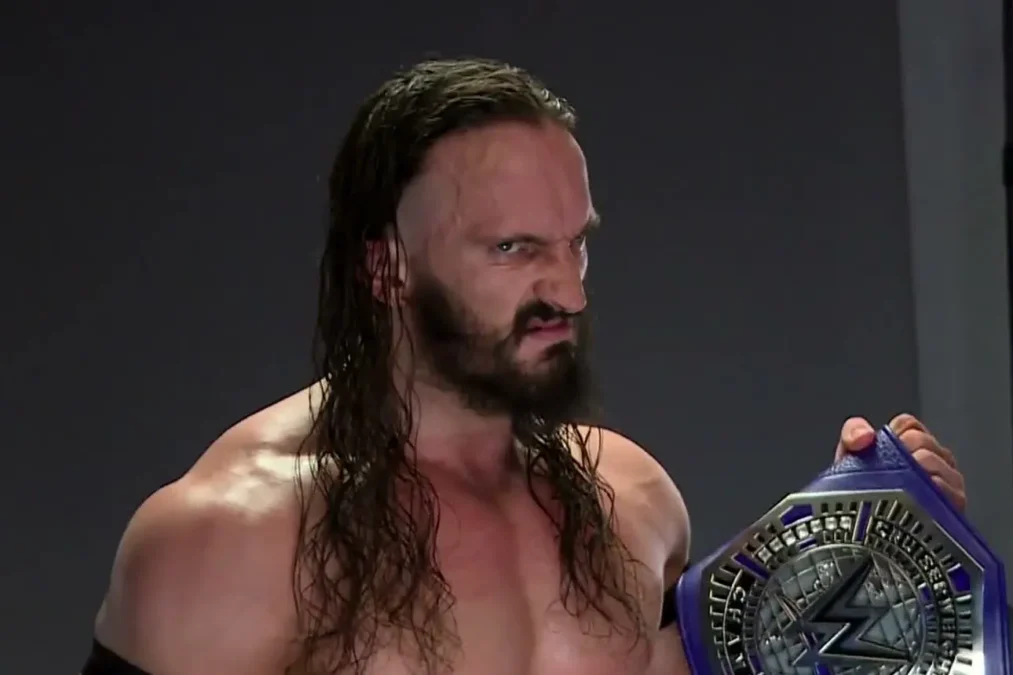 Neville with long hair and a beard, scowling at the camera and holding the purple WWE Cruiserweight Championship belt
