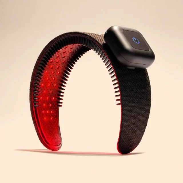 The Capillus HairBand, a black fabric headband with rows of red laser diodes inside and a square control pod on top