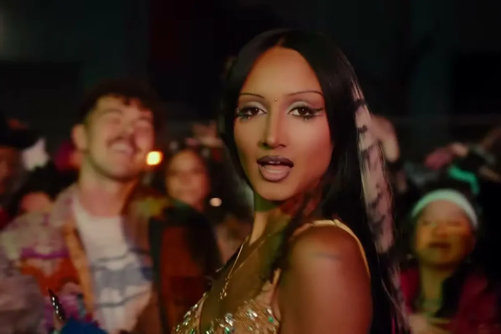 Rhea Raj in a gold top at a crowded party in the Haute Couture music video