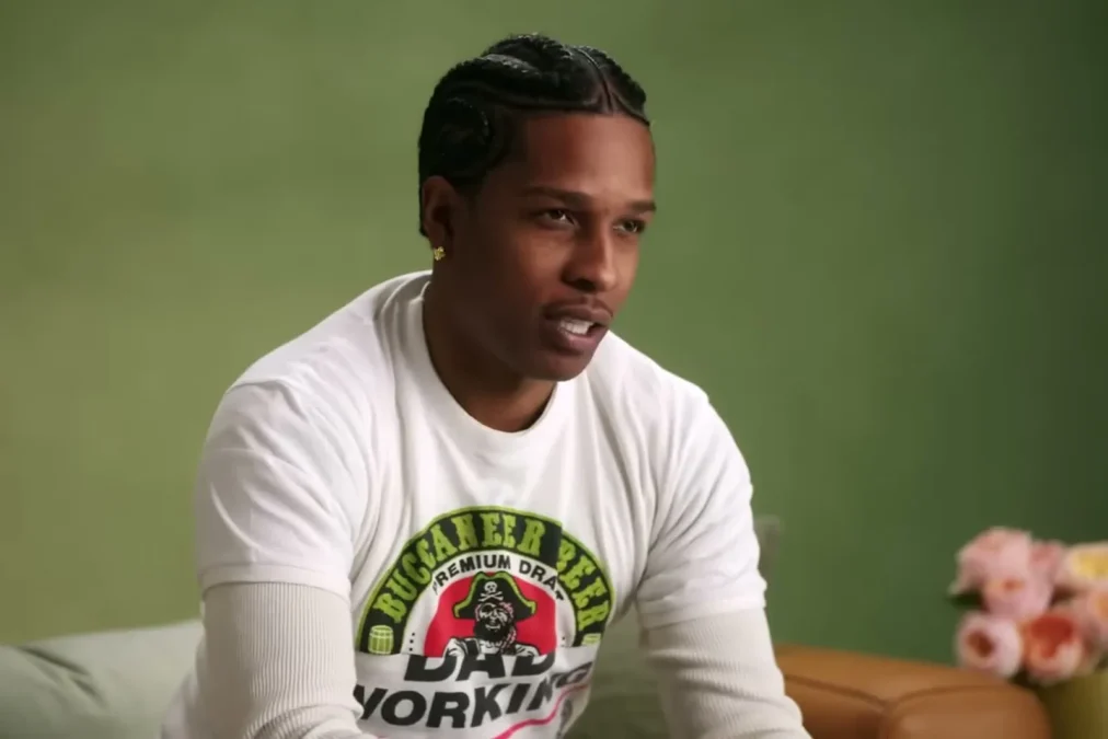 A$AP Rocky in a white graphic long-sleeve shirt talking on a green couch in a Vogue video