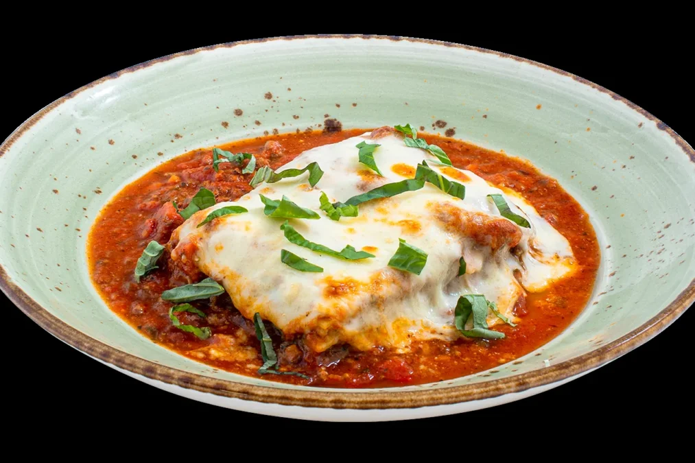 Russo's Lasagna, layered fresh pasta with meat sauce and melted cheese on a green plate
