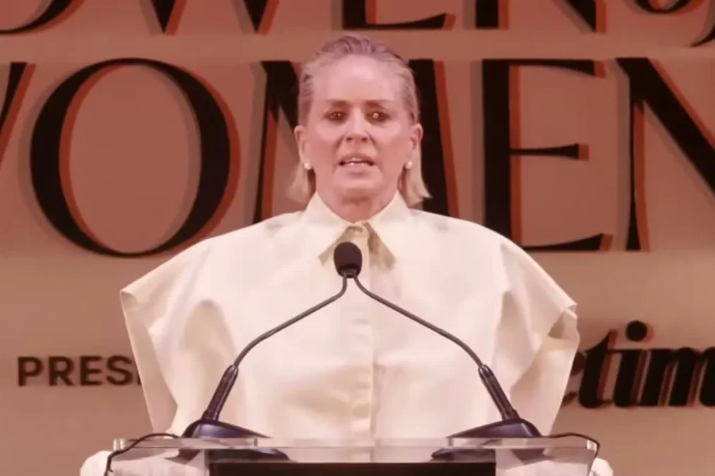 Sharon Stone in a cream outfit speaking at a Variety Power of Women podium in 2025
