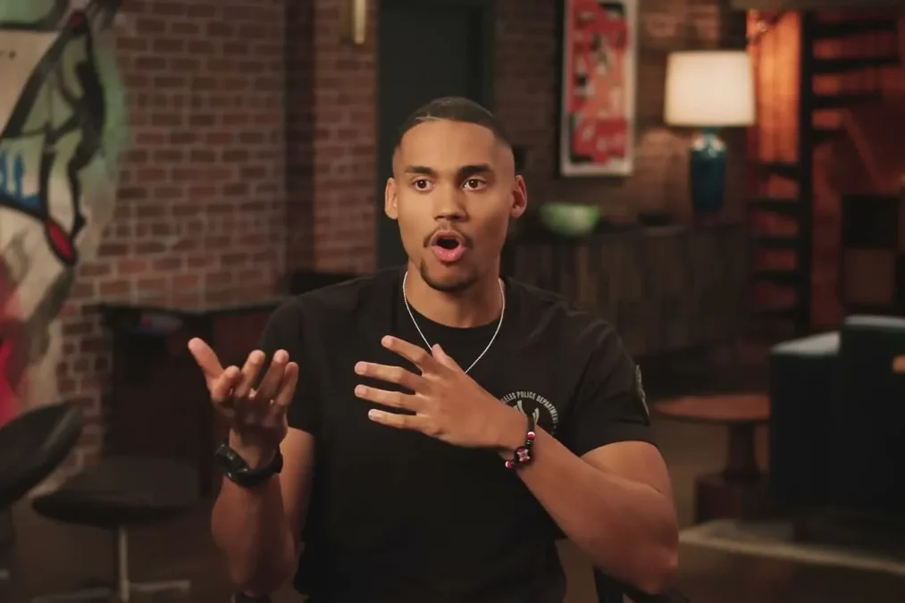 Adain Bradley in a black T-shirt with an LAPD patch talking in an interview
