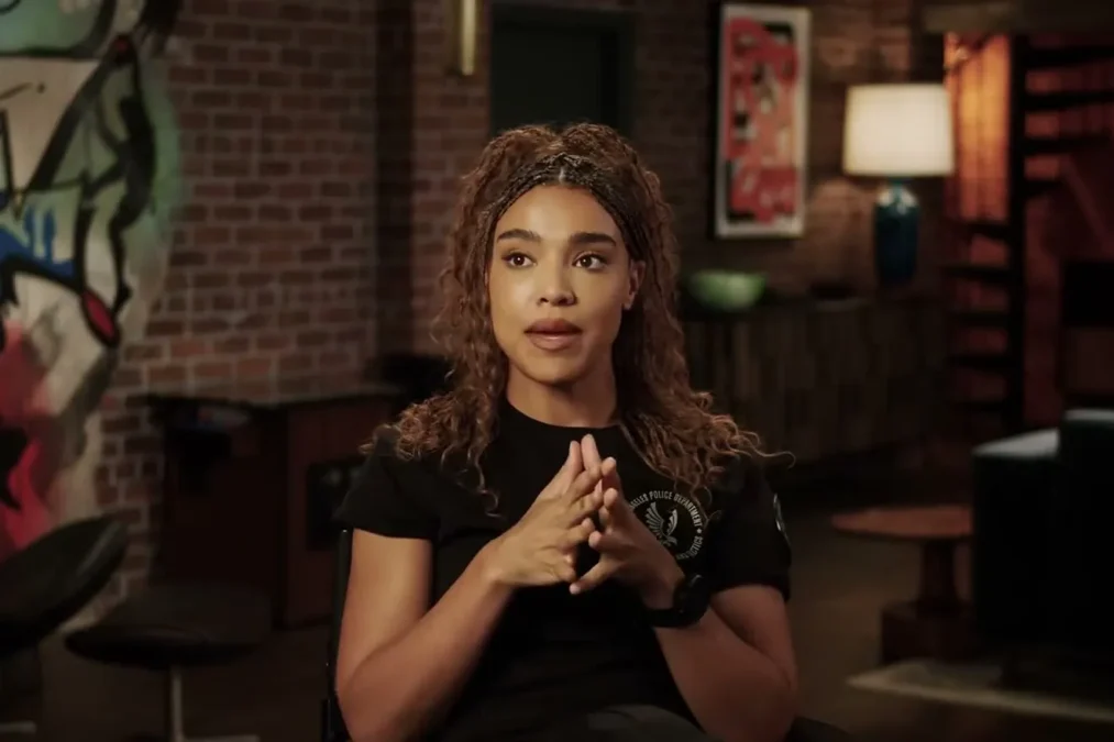 Lucy Barrett with curly hair pulled up talking in an interview