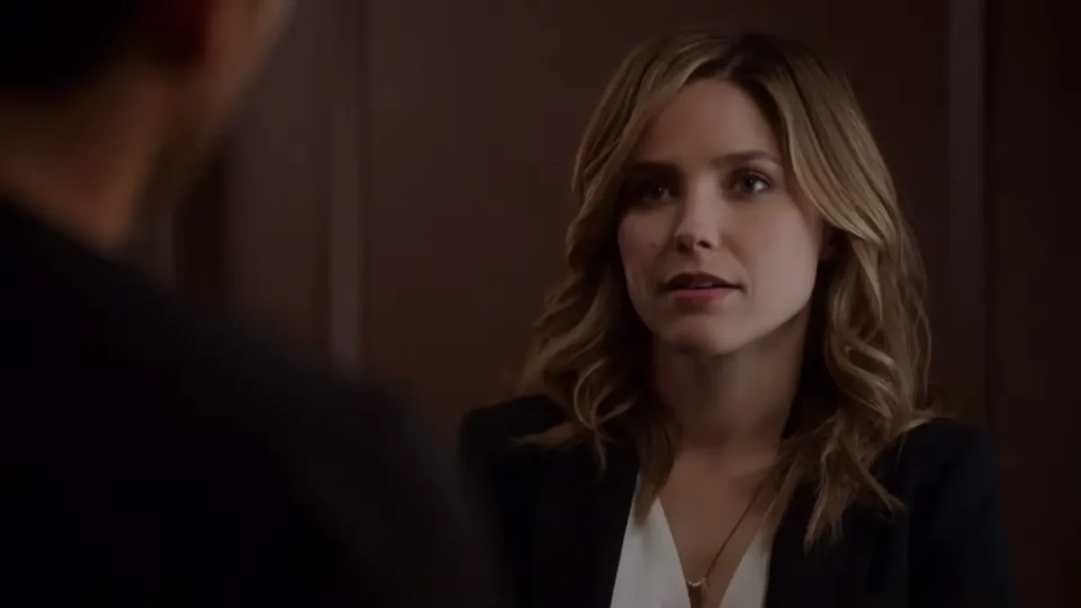 Sophia Bush as Detective Erin Lindsay in a dark blazer in a dimly lit room in Chicago P.D.