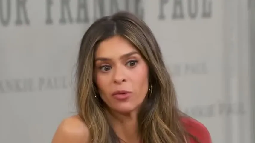 Taylor Frankie Paul, with long highlighted brown hair and a red top, during a live TV interview