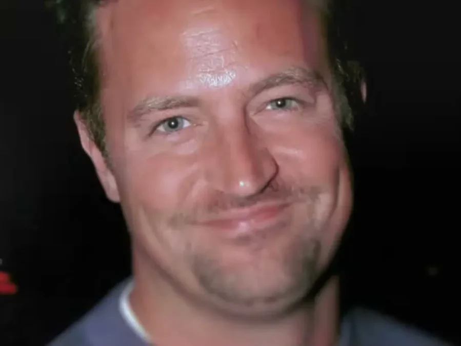 Matthew Perry smiling widely in a close-up archival photo