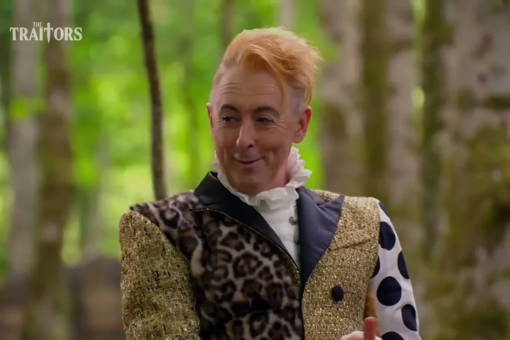 Alan Cumming in a leopard-print and polka-dot jacket in a forest on The Traitors