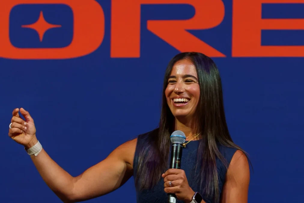LA Orbit president Ana Mendy smiling with a microphone on stage in front of a giant Orbit logo at Intuit Dome