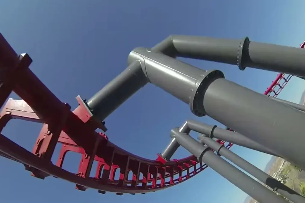 X2's red track and gray steel supports seen from a rider's seat against a blue sky