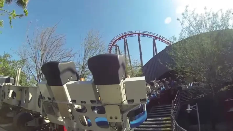 The X2 roller coaster's winged seats, seen from the front of the train, with the ride's red track looping against a blue sky at Six Flags Magic Mountain