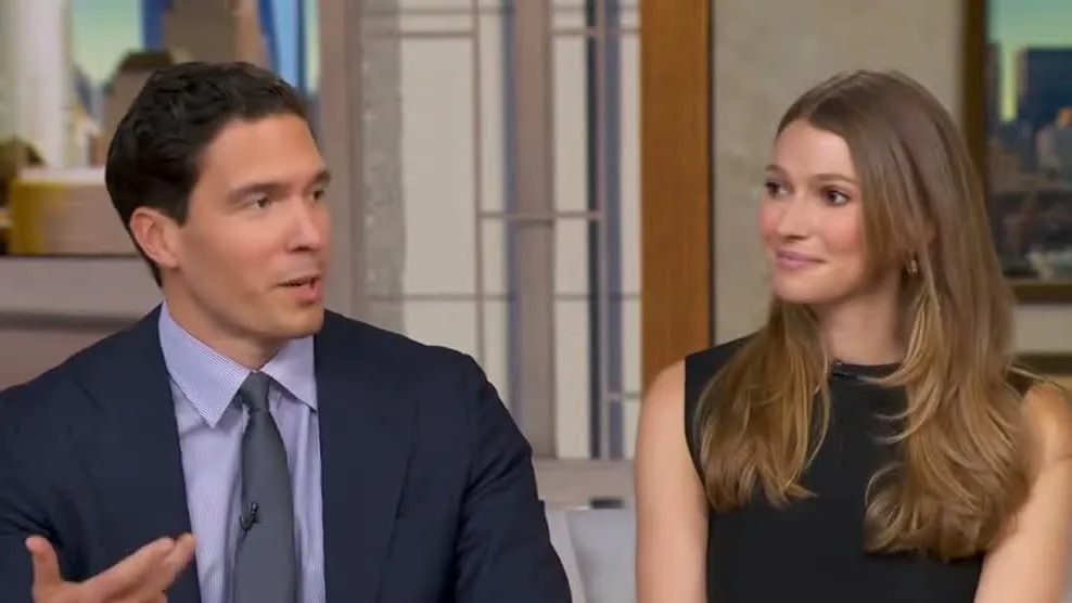 Will Reeve in a navy suit speaking on the Good Morning America couch as his wife, Amanda, sits beside him and looks at him