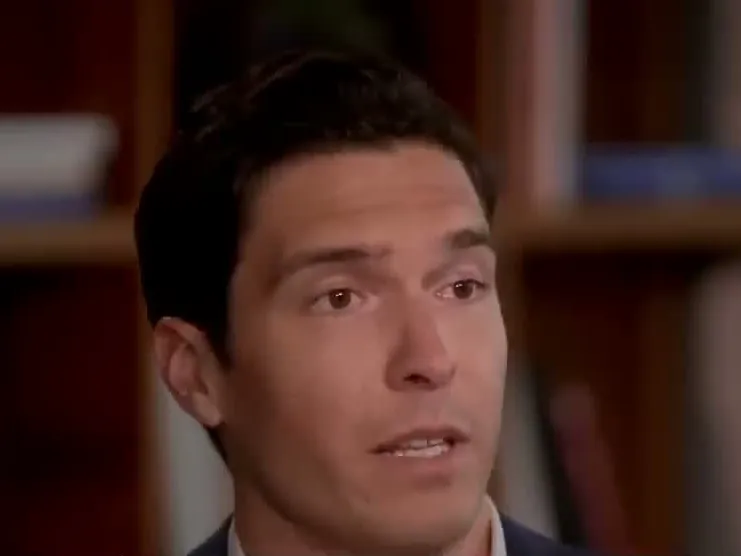 Will Reeve speaking in front of a bookshelf in a 2024 interview