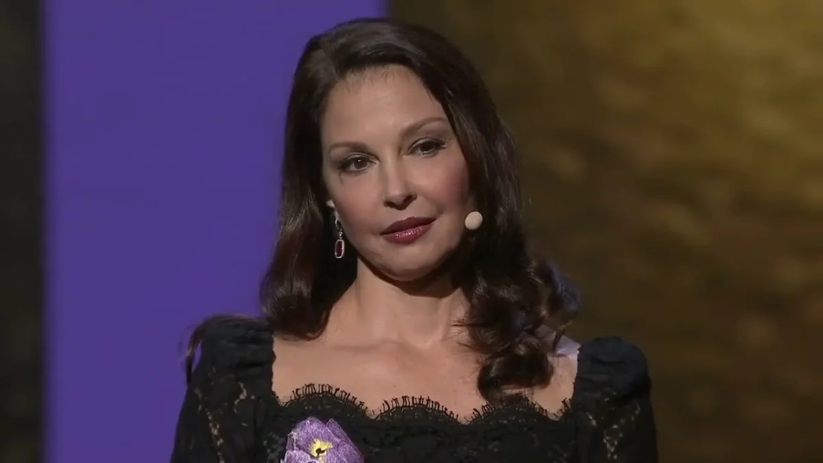 Ashley Judd in a black lace dress speaking on the TED stage