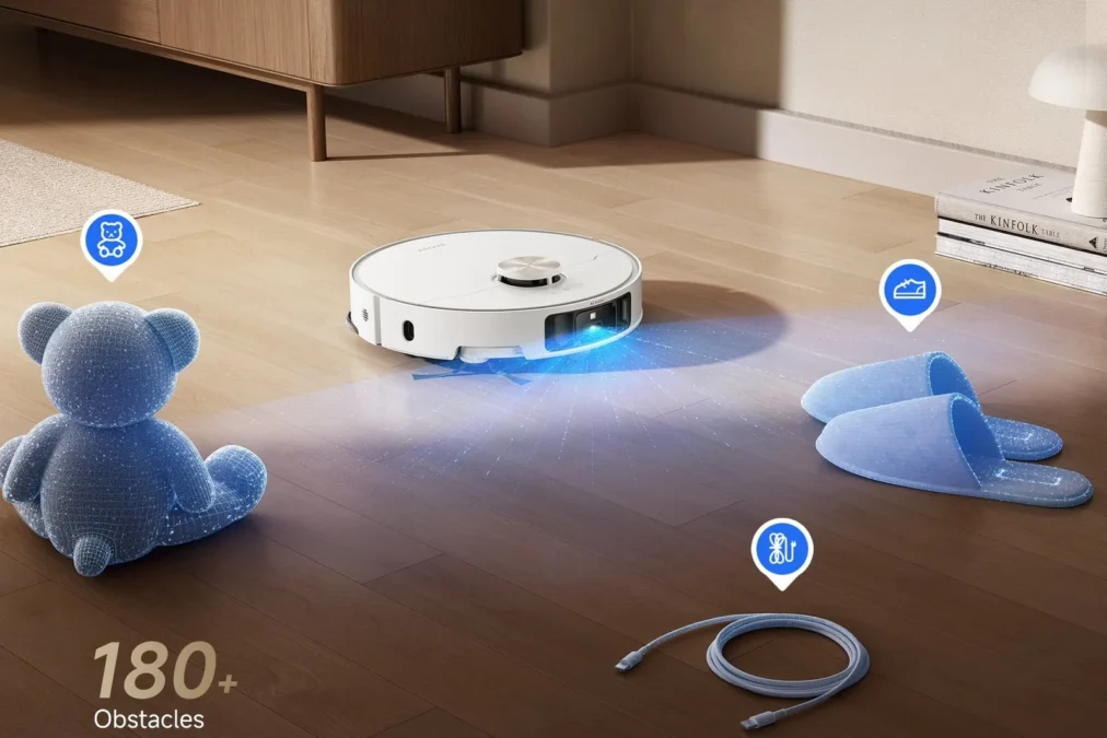 A white Dreame L50 Ultra robot vacuum on a wood floor, scanning around a teddy bear, slippers and a cable