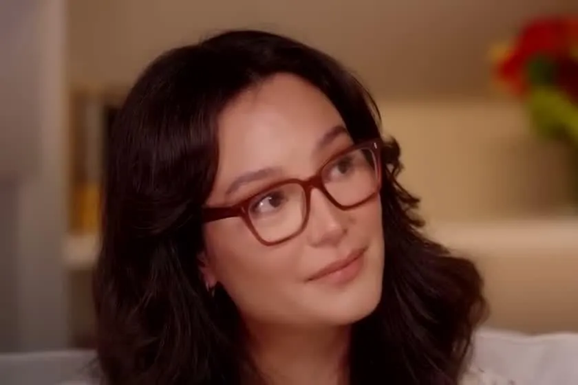 Emma Heming Willis with long dark hair and red glasses smiling during an interview