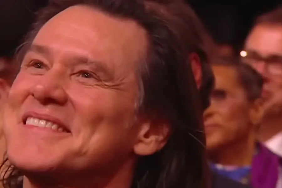 Jim Carrey smiling and applauding in the audience at the César Awards ceremony in Paris