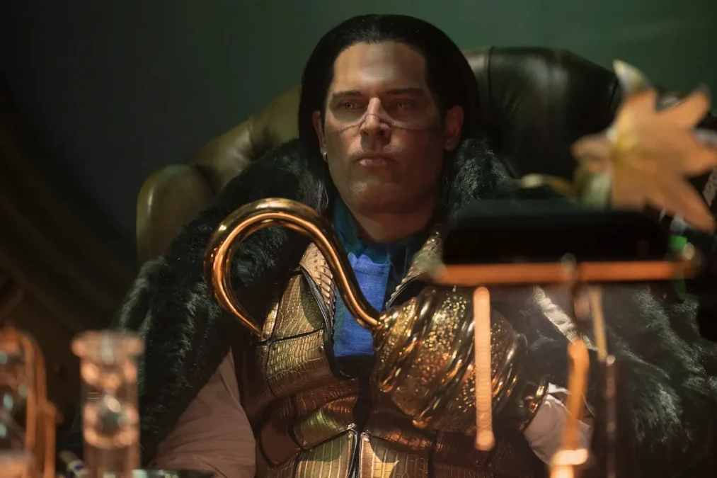 Joe Manganiello as Mr. 0, with slicked-back hair, a scar across his face and a golden hook hand, sitting in a chair