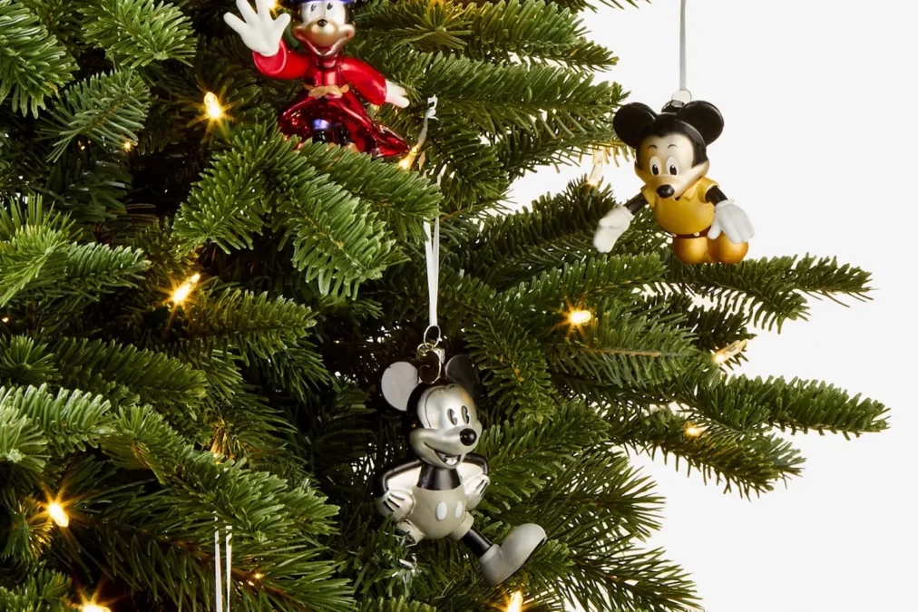 Blown-glass Mickey Mouse balloon ornaments hanging on a Christmas tree, including Sorcerer's Apprentice Mickey