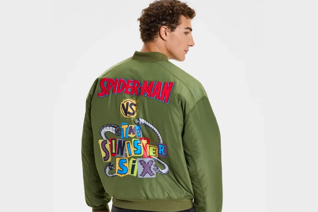 A man seen from behind in a green bomber jacket with Spider-Man vs. the Sinister Six lettering on the back
