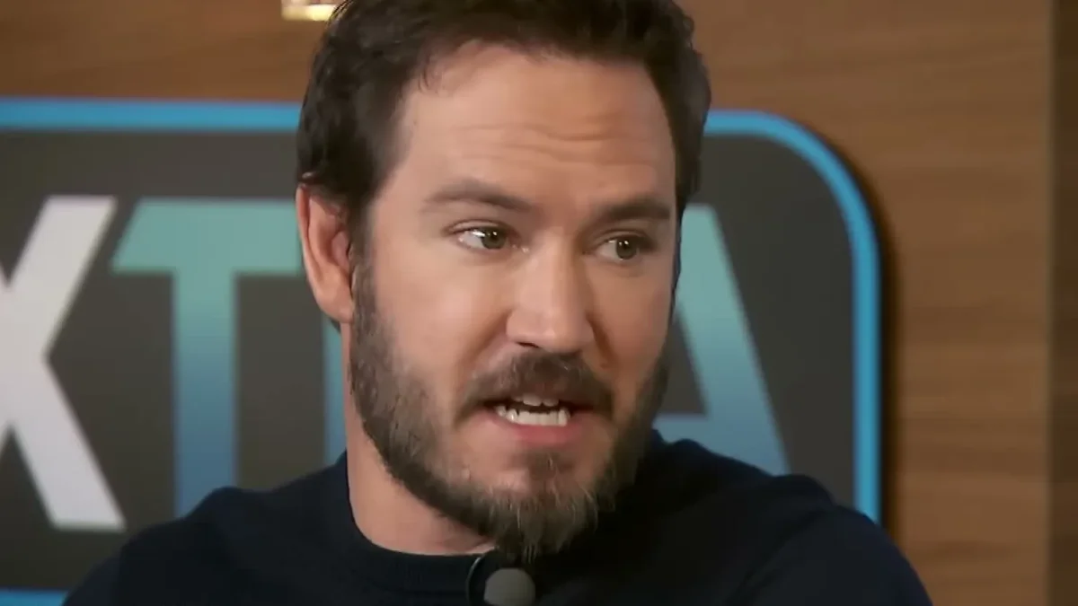 Mark-Paul Gosselaar in a dark sweater speaking during an Extra interview
