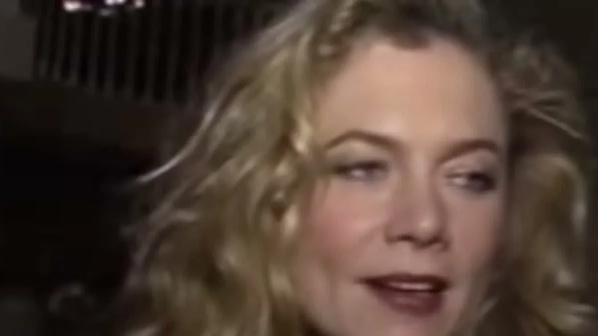 Kathleen Turner with curly blonde hair glancing to the side during a 1989 interview